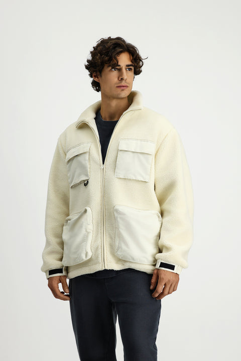 Off-white plush sweatshirt with zippered pockets.