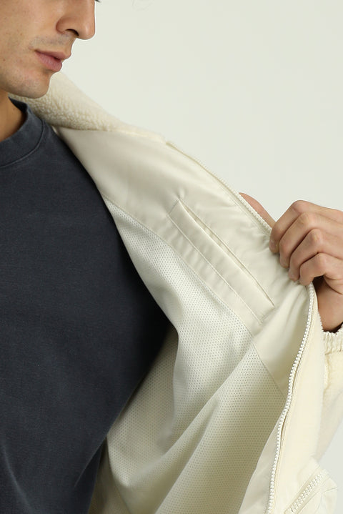 Off-white plush sweatshirt with zippered pockets.