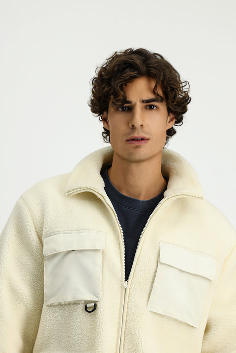 Off-white plush sweatshirt with zippered pockets.