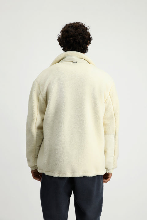 Off-white plush sweatshirt with zippered pockets.